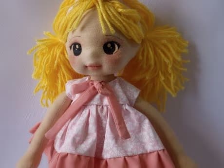 Selfie de boneca de pano loira com vestido rosa claro e escuro e olhos escuros