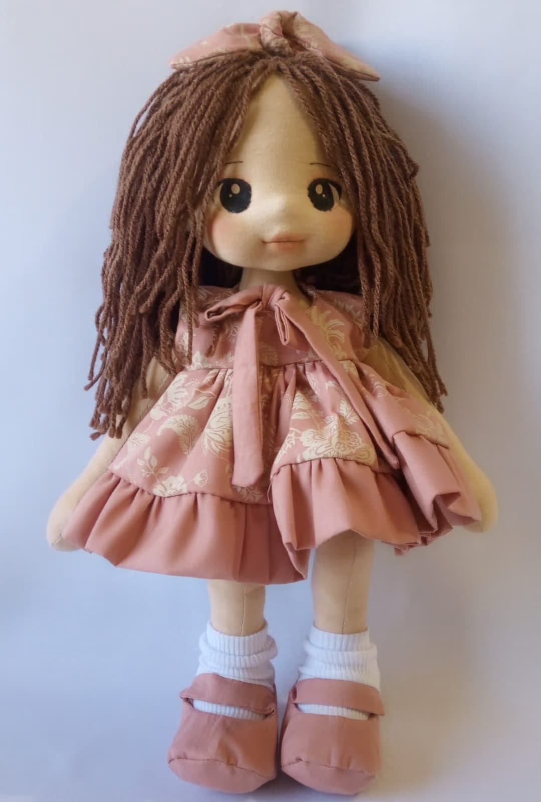 Boneca de pano morena com vestido salmão com desenhos e sapatos salmão, cabelo castanho