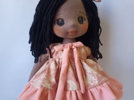 Selfie de boneca de pano negra com vestido salmão